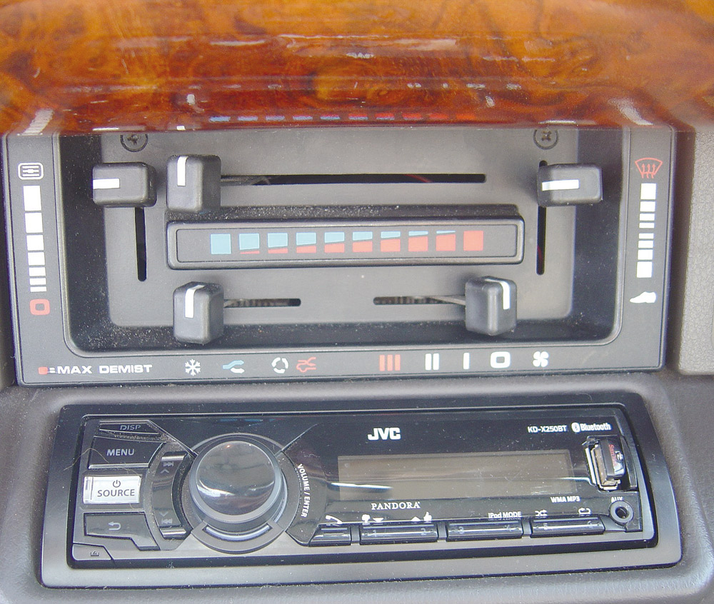 Abaixo do painel há o sistema do ar-condicionado; já o rádio original foi trocado por uma unidade JVC com entrada USB e auxiliar 