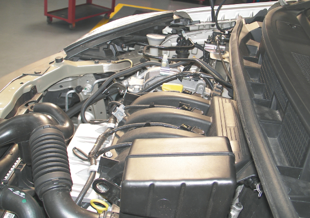 O motor, visto de lado: em primeiro plano a tubulação do coletor de ar; o filtro fica escondido atrás da caixa